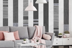 Pink pillows on grey couch in white apartment interior with poster and lamps above table. Real photo